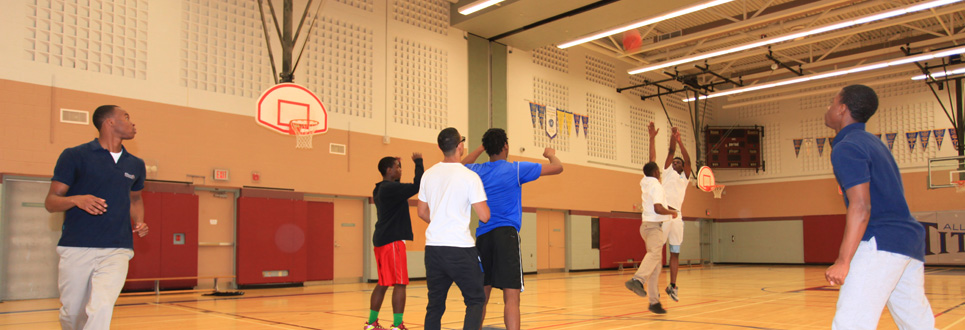 Several students playing basketball in a gym.